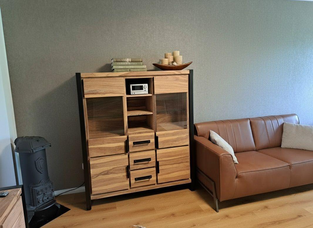 Holzschrank mit Glasfronten, Sofa und Kaminofen im Wohnzimmer.