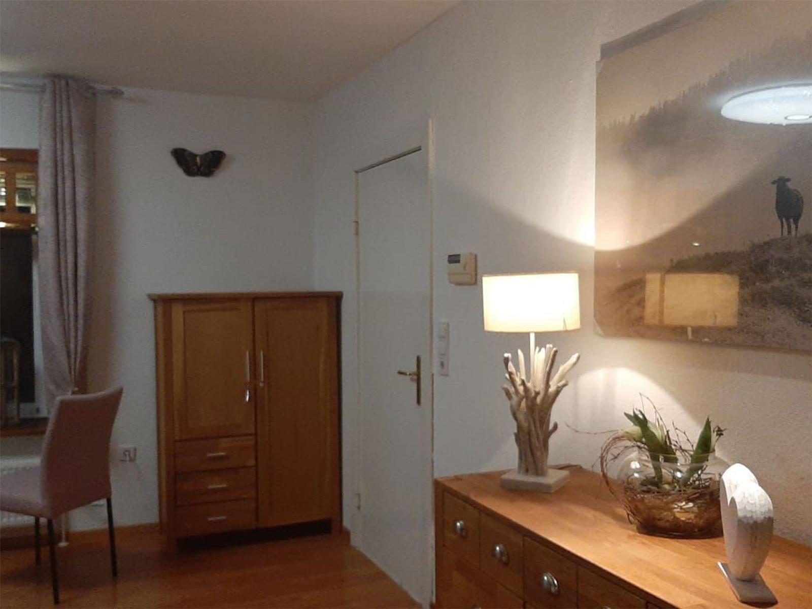 Ein Raum mit Holzmöbeln, einer Lampe und einem Bild an der Wand.