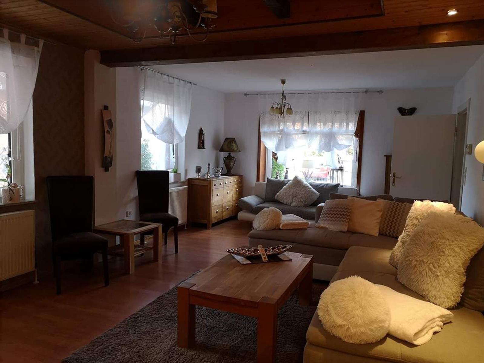 Wohnzimmer mit Sofa, Couchtisch und Holzdecke