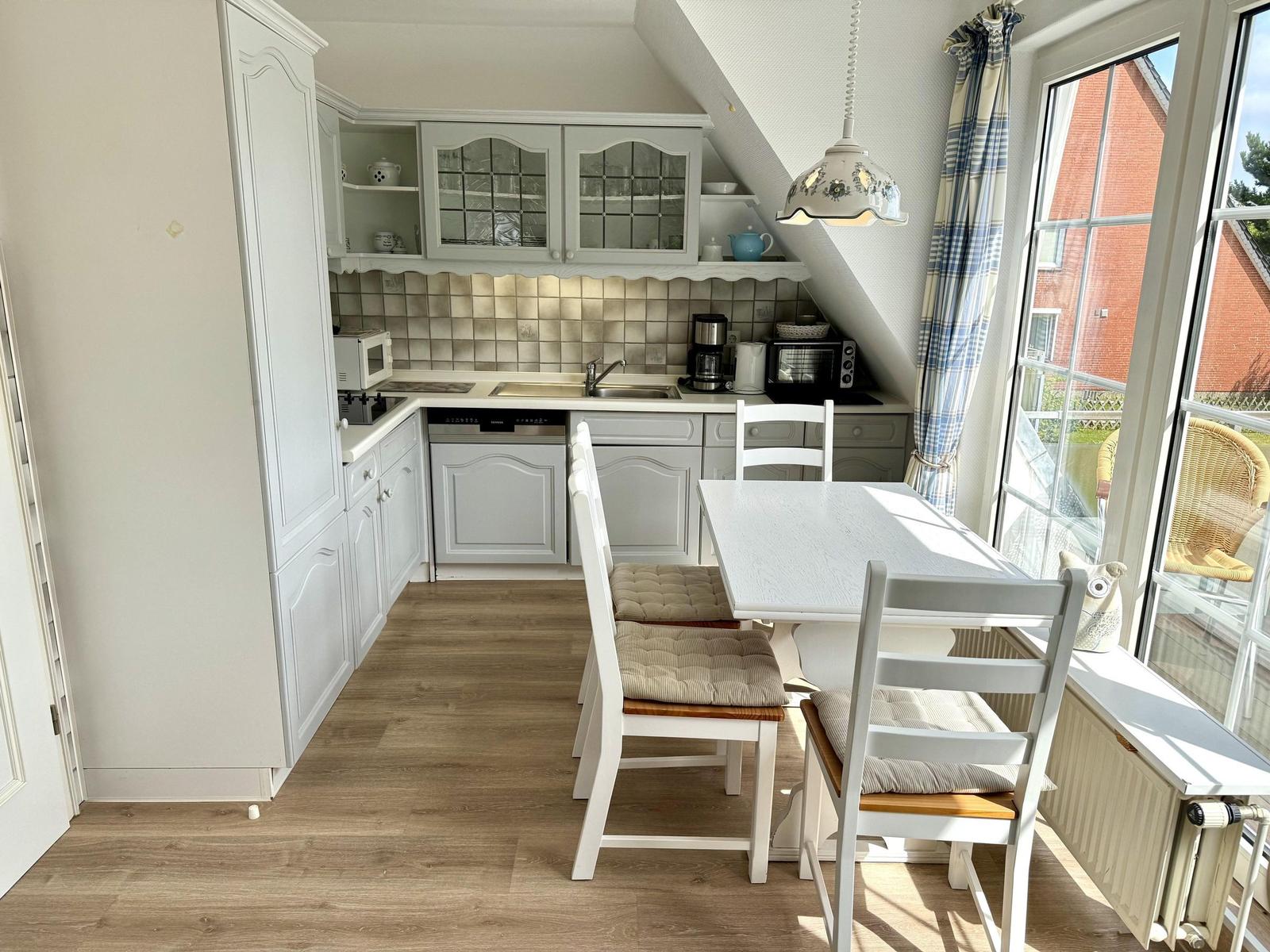 Kitchen with dining table and seating. Window with view outside.