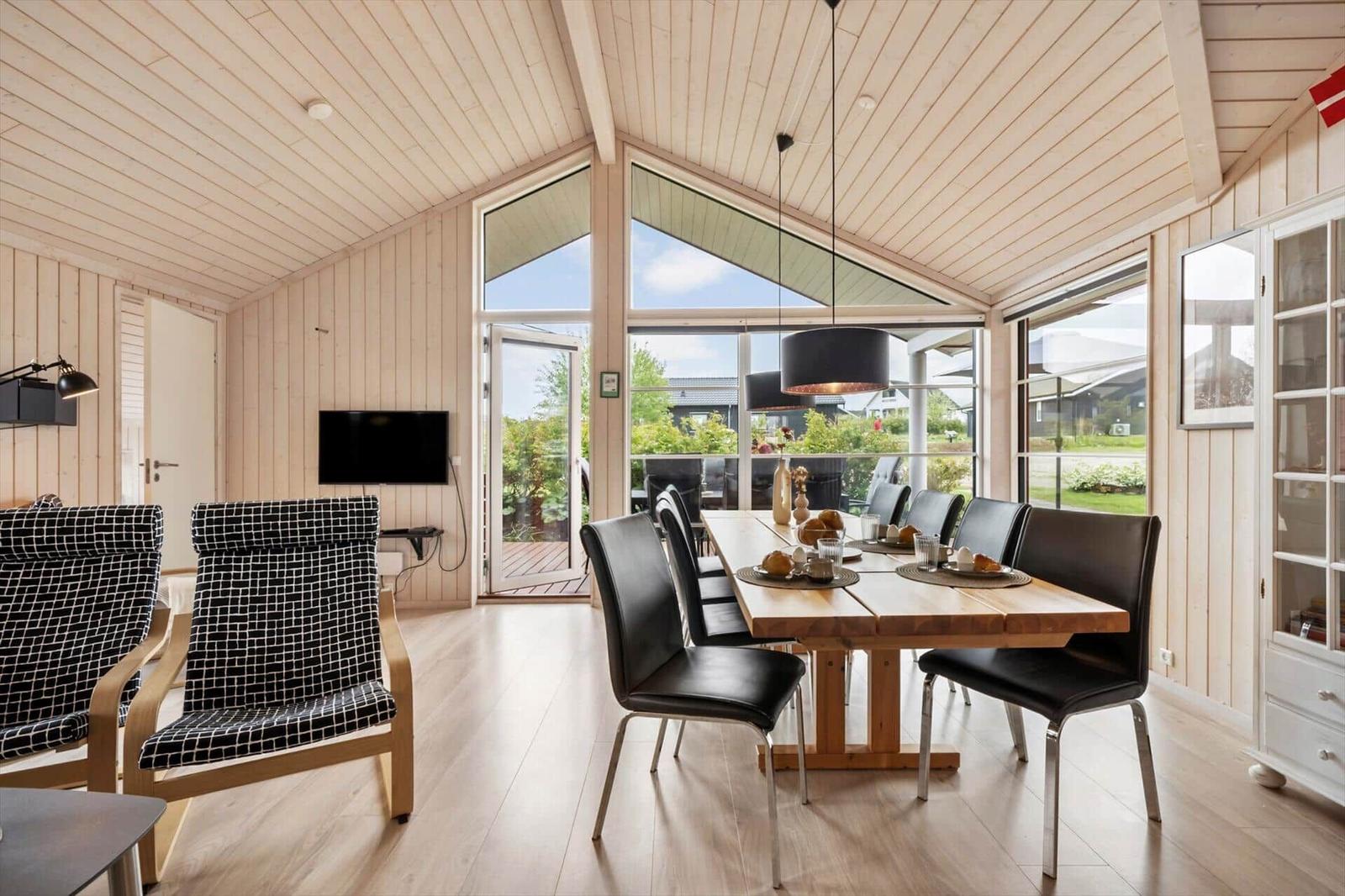 Dining area with wooden table, black chairs, and large window view.