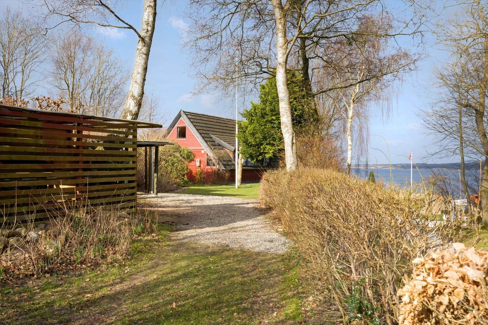 Haus mit Blick auf Wasser, gepflasterter Weg und Bäume