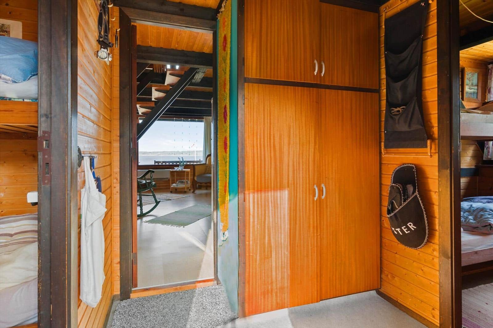 Eingangsbereich mit Kleiderschrank und Blick in Wohnbereich mit Blick auf Wasser.
