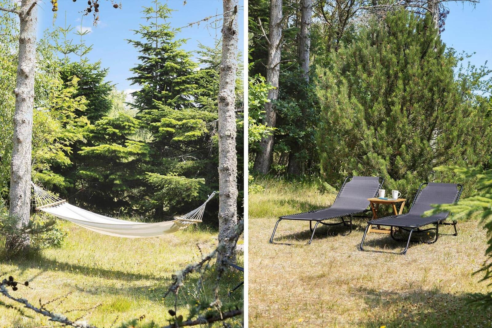 Hammock between trees and two chairs with table on grass.