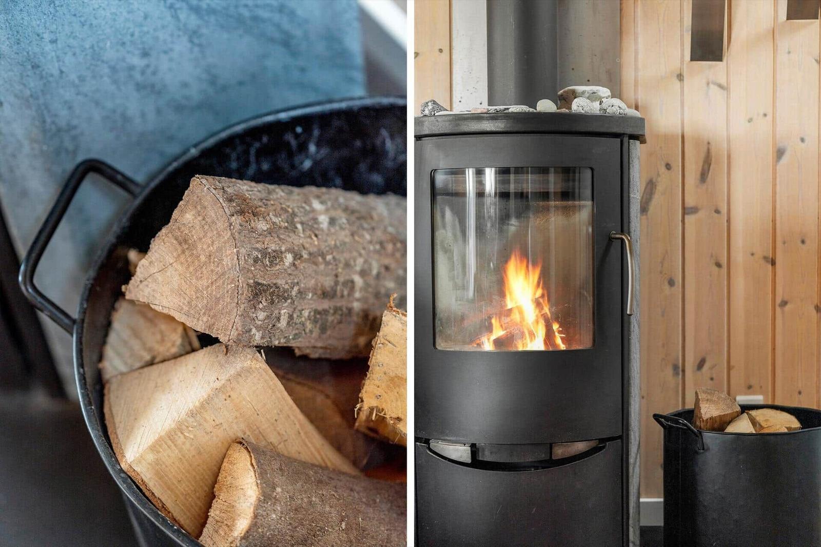 Holzofen mit brennendem Feuer und Holzstapel in einem Raum mit Holzwand.