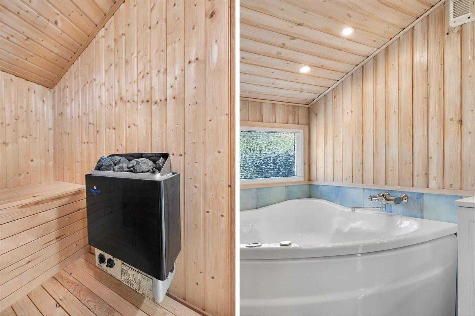 Sauna with wooden walls and stone heater. Bathtub with window and blue tile.