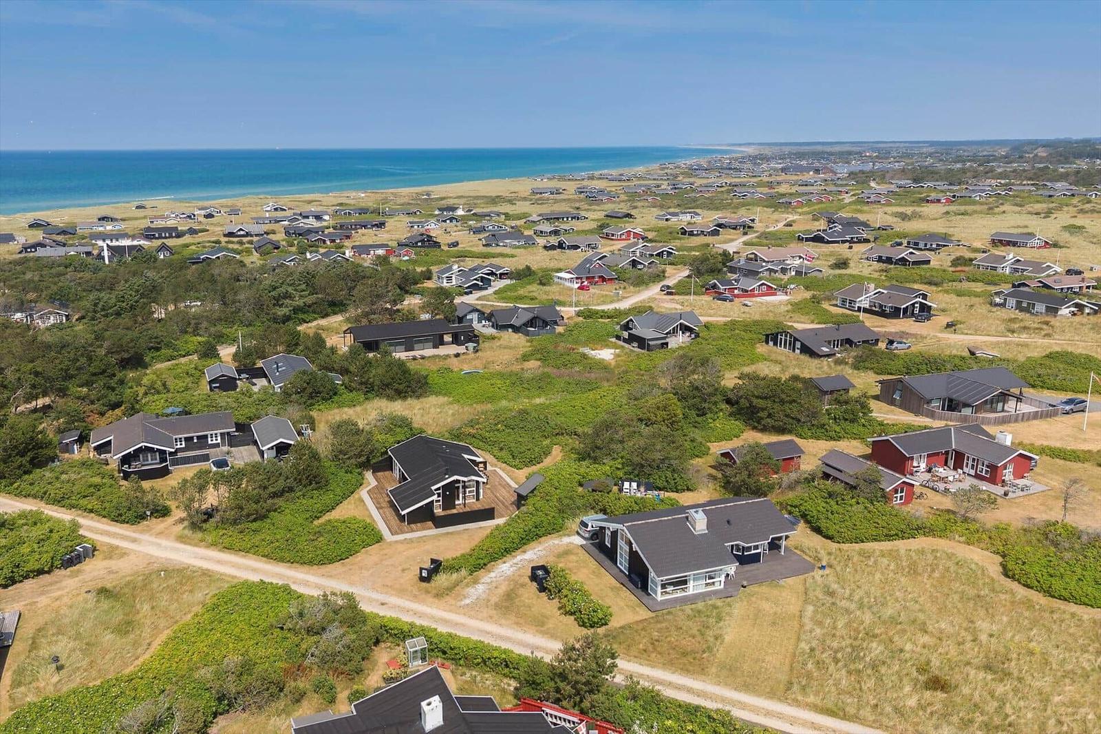 Aerial view of coastal holiday homes with ocean in background.