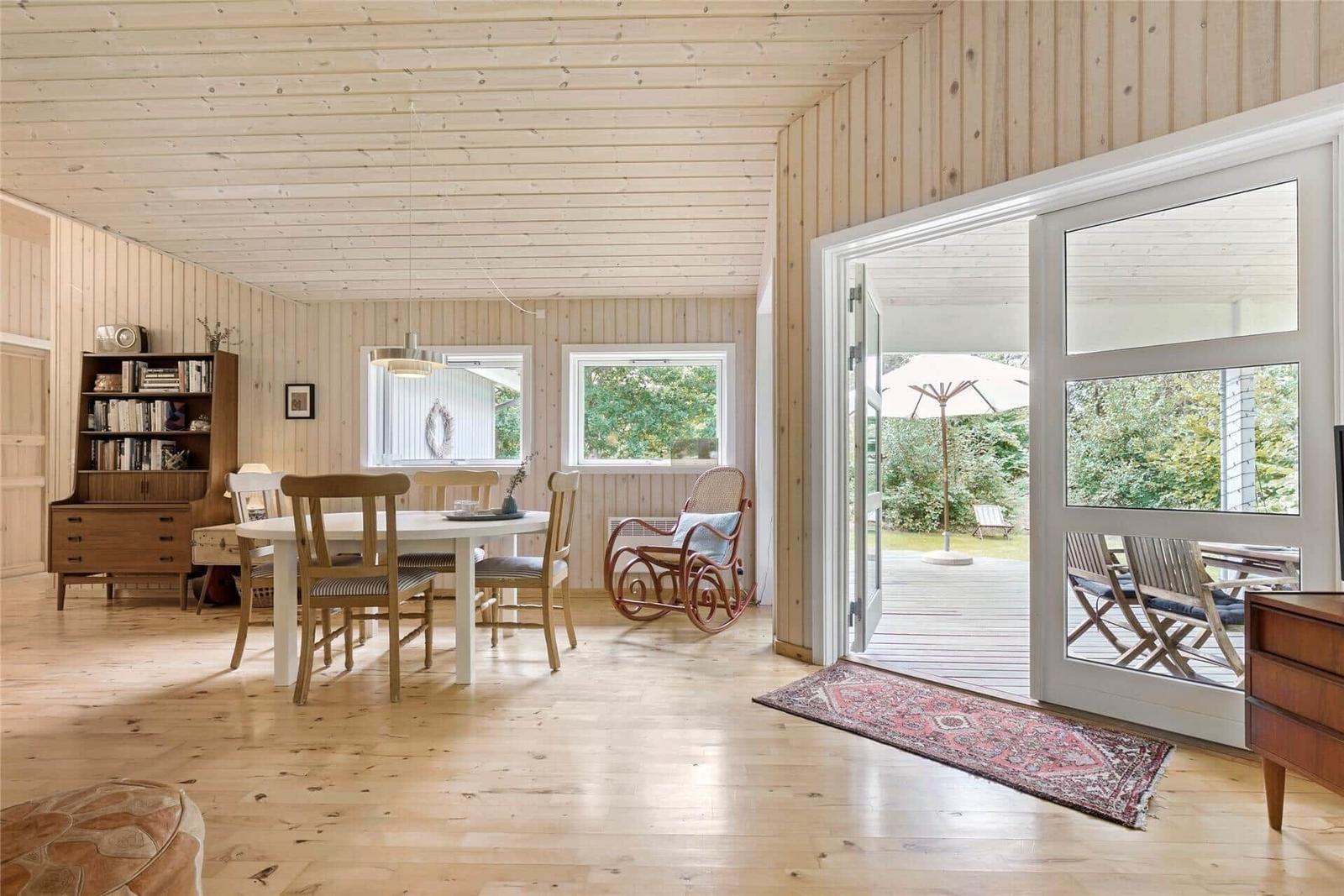 Bright room with dining area, hardwood floor, and view to the terrace.