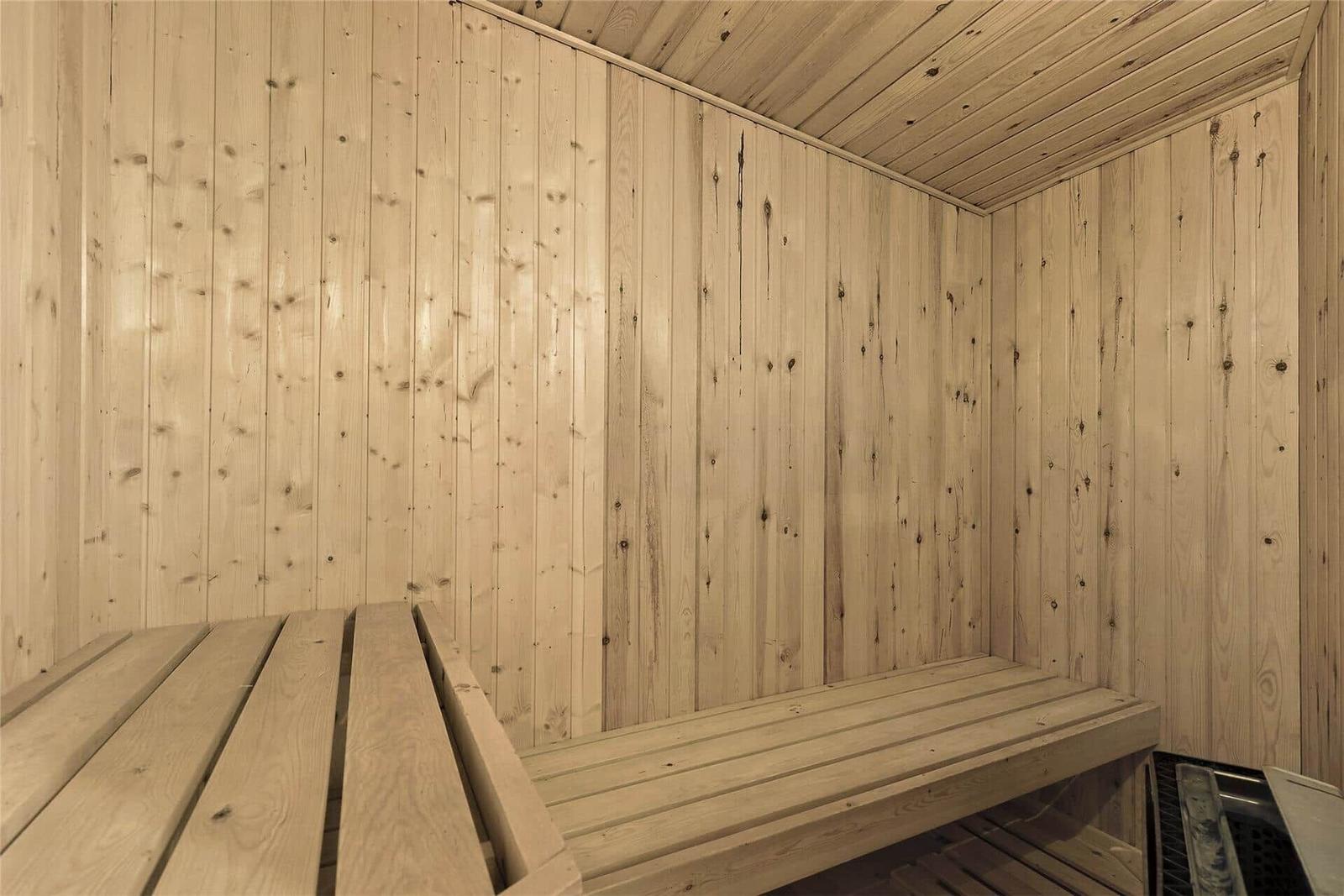 Badezimmer mit Dusche, Toilette und Waschbecken. Schwarze Fliesen und weiße Wände.