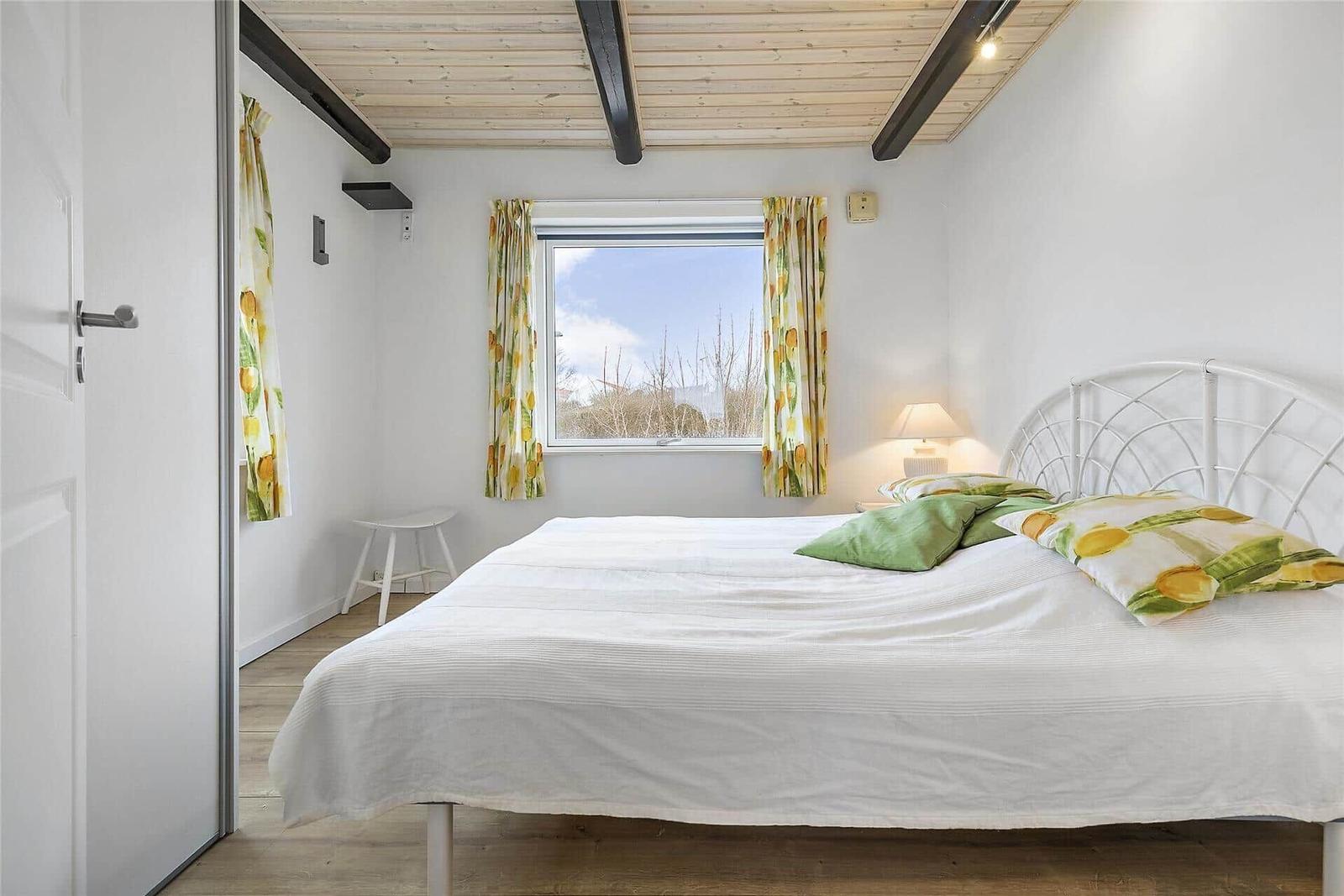 Schlafzimmer mit Bett, Fenster, Stuhl und Klimaanlage.