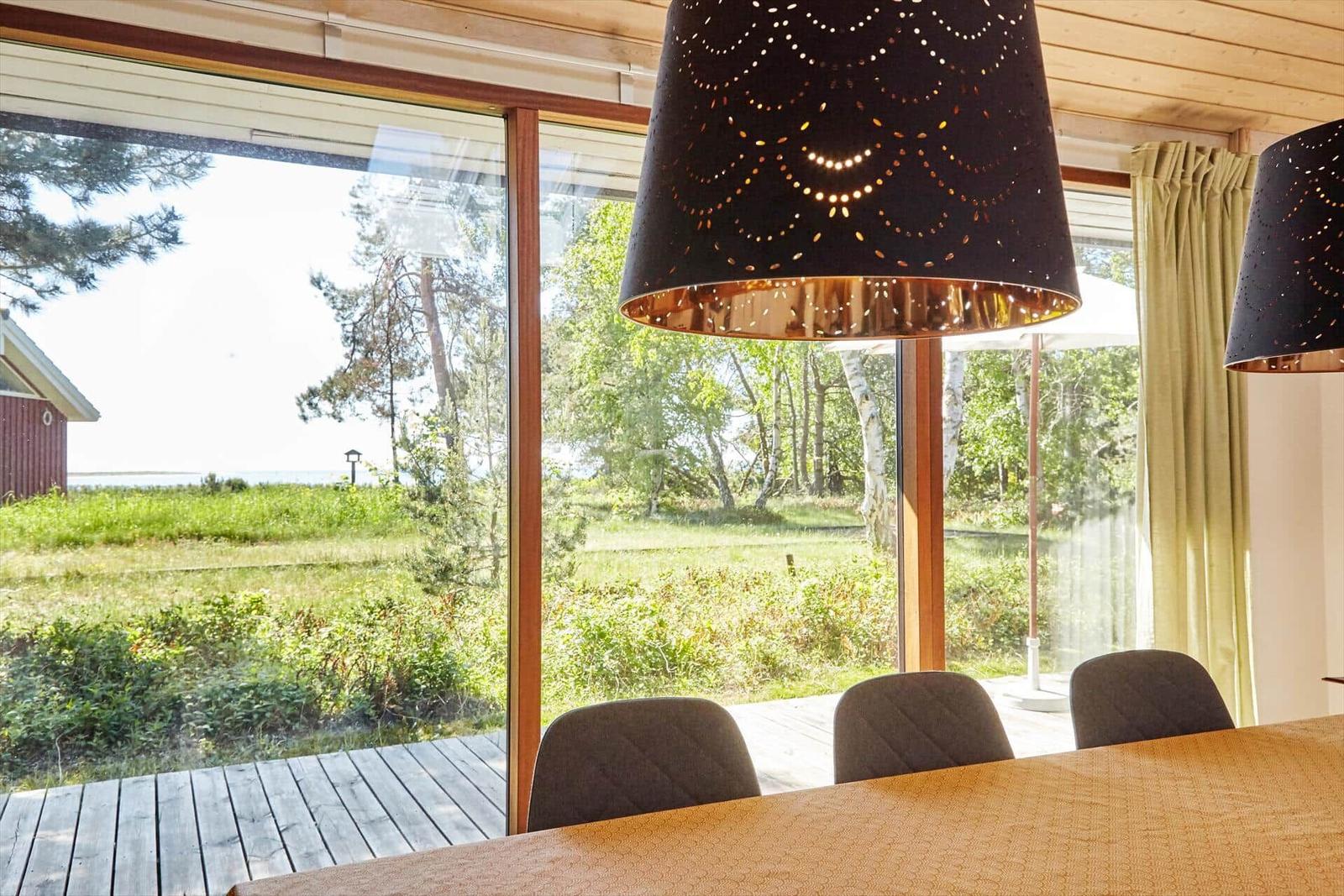 Wohnzimmer mit Sessel, Kamin und Wandbild. Holzfußboden und Stehlampe sichtbar.