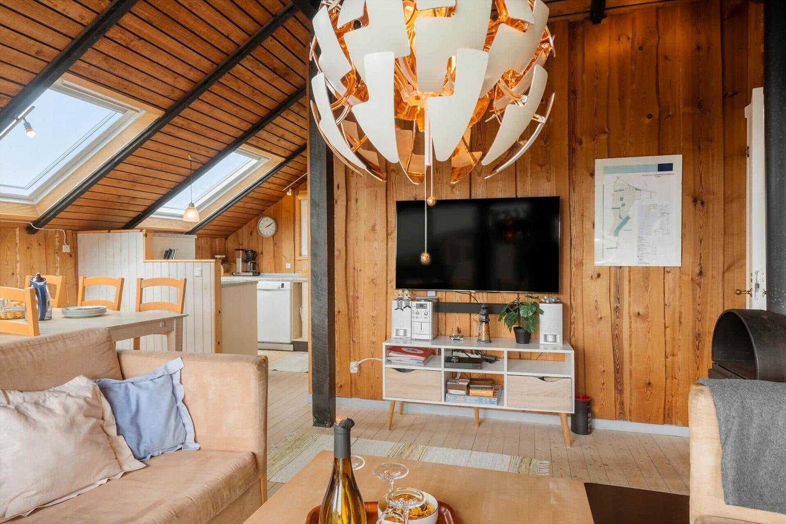 Hallenraum mit Holzwänden, Tür zum Balkon und Spiegel an der Wand.
