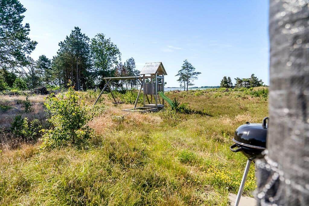 Grüner Garten mit Spielplatz und Blick aufs Wasser