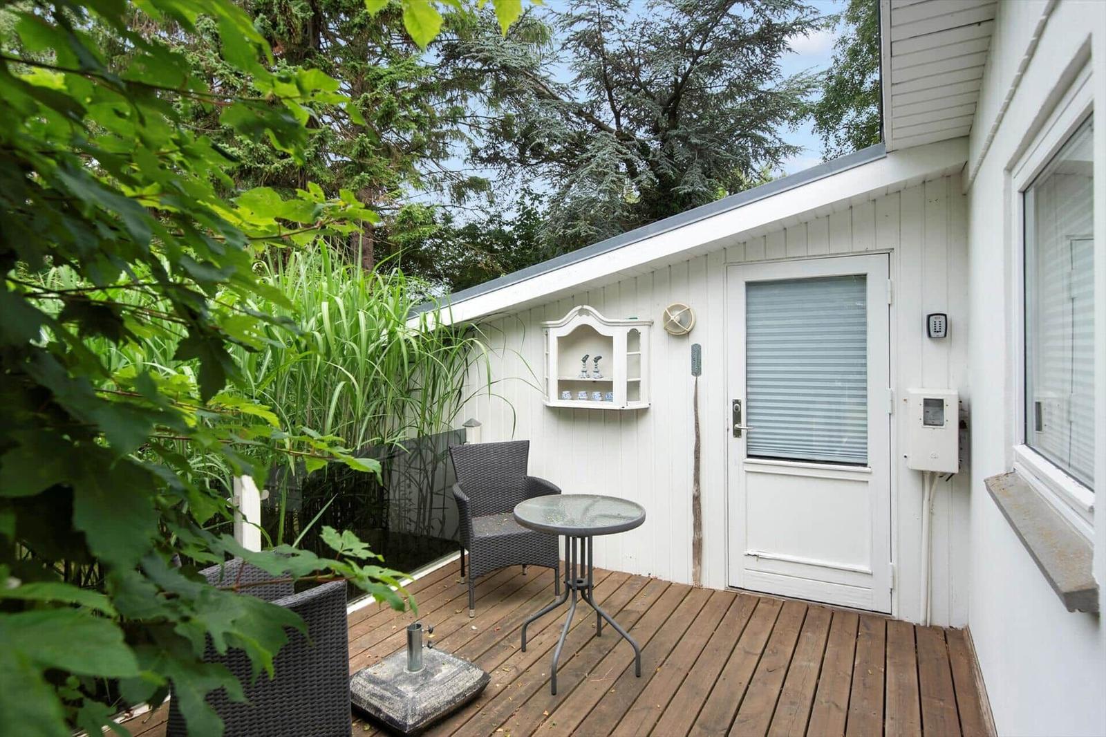 Wohnhaus mit Terrasse und Gartenbereich unter blauem Himmel