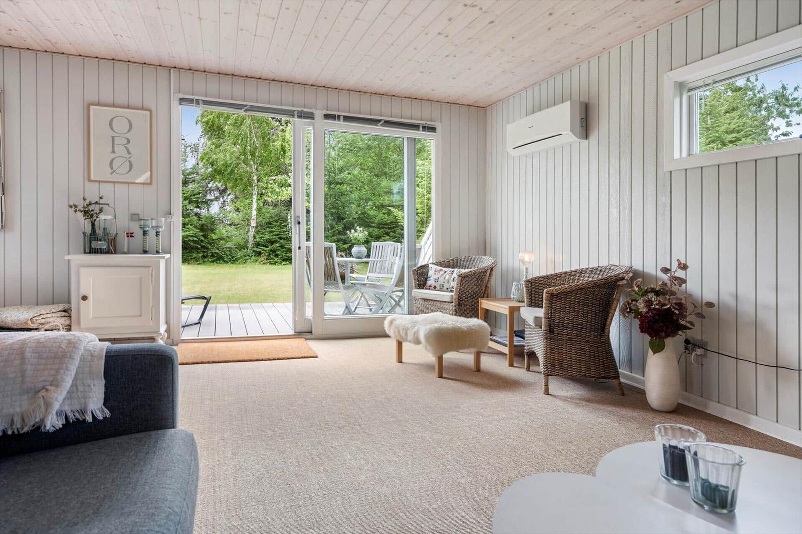 Living room with sliding doors to the terrace, two chairs and a sofa.