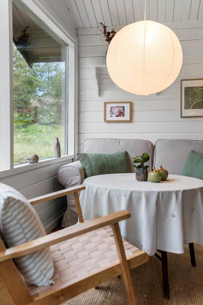 Ein Wohnzimmer mit einem schwarzen Sofa, einem runden Tisch und einem Holzstuhl.