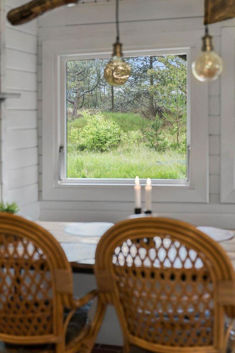 Deckenbalken aus Holz und weiße Paneelen. Hängende Lampe mit Glühbirnen.