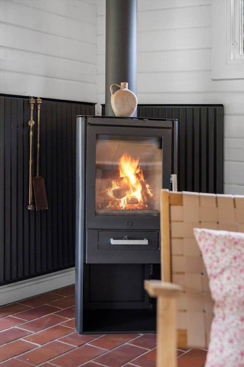 Essbereich mit Rattanstühlen und Holztisch an weißer Wand.