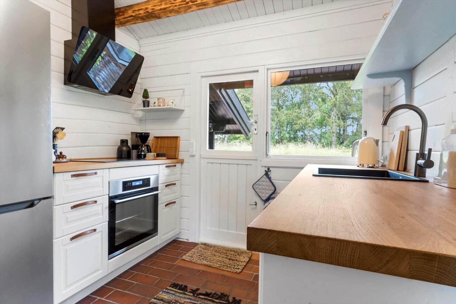 Essbereich mit Bambusstühlen und Holztisch. Durchgang in Wohnbereich mit Kamin und Terrasse.