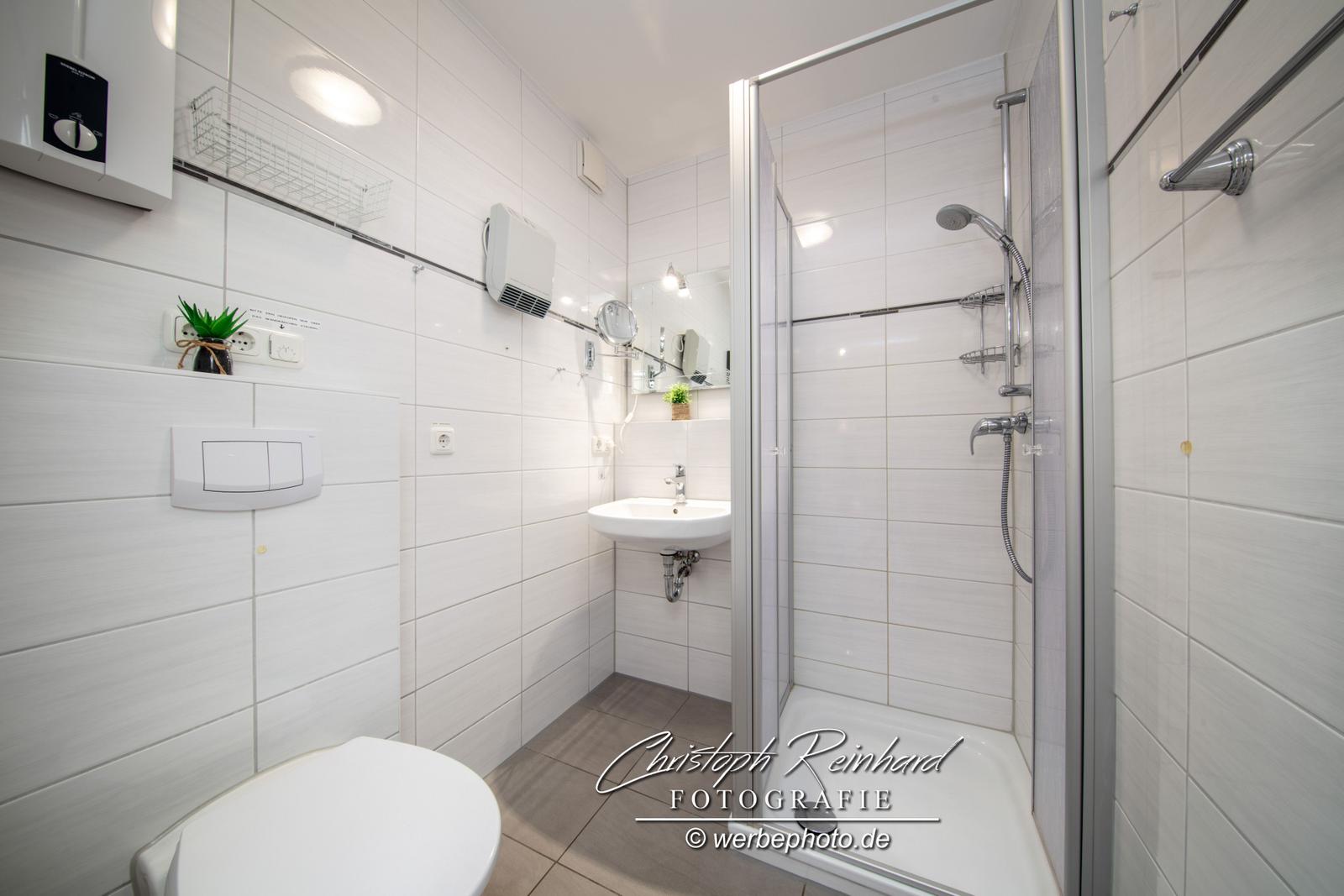 Das freundliche Badezimmer ist mit Dusche, WC und Waschbecken ausgestattet.