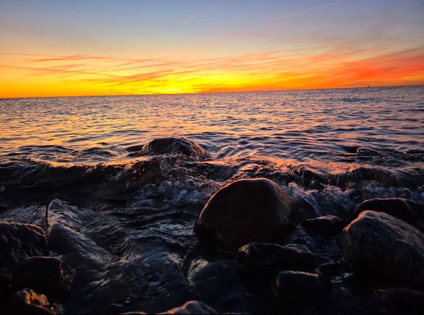 Farbenprächtiger Sonnenuntergang über der Ostsee mit leuchtendem Himmel und ruhiger Küstenstimmung.