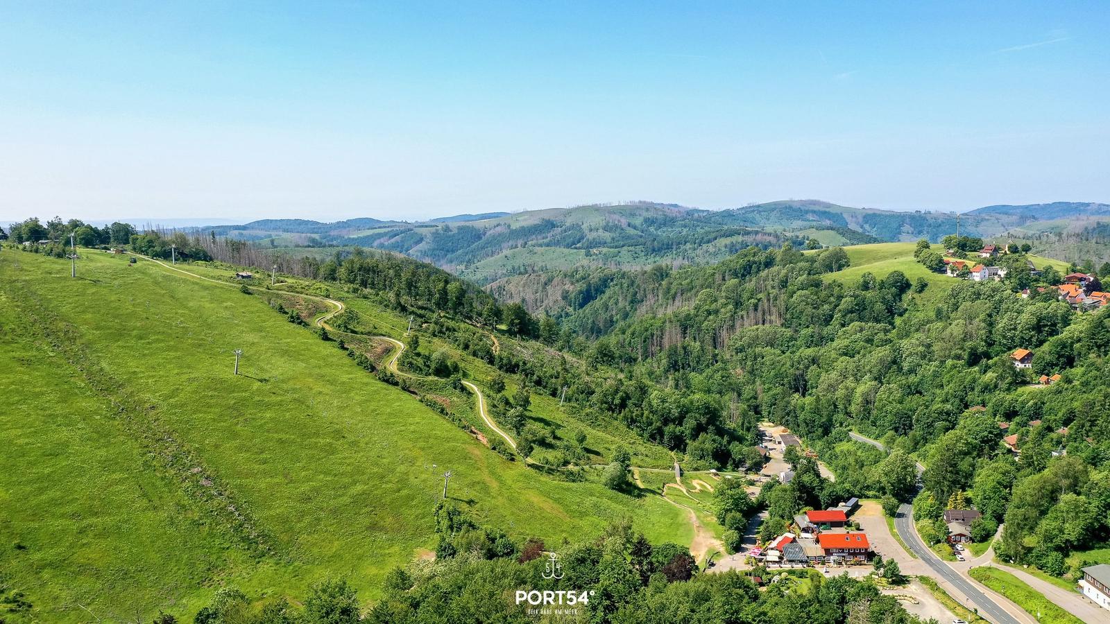 Ein ruhiger See mit grüner Umgebung und klarem Himmel.