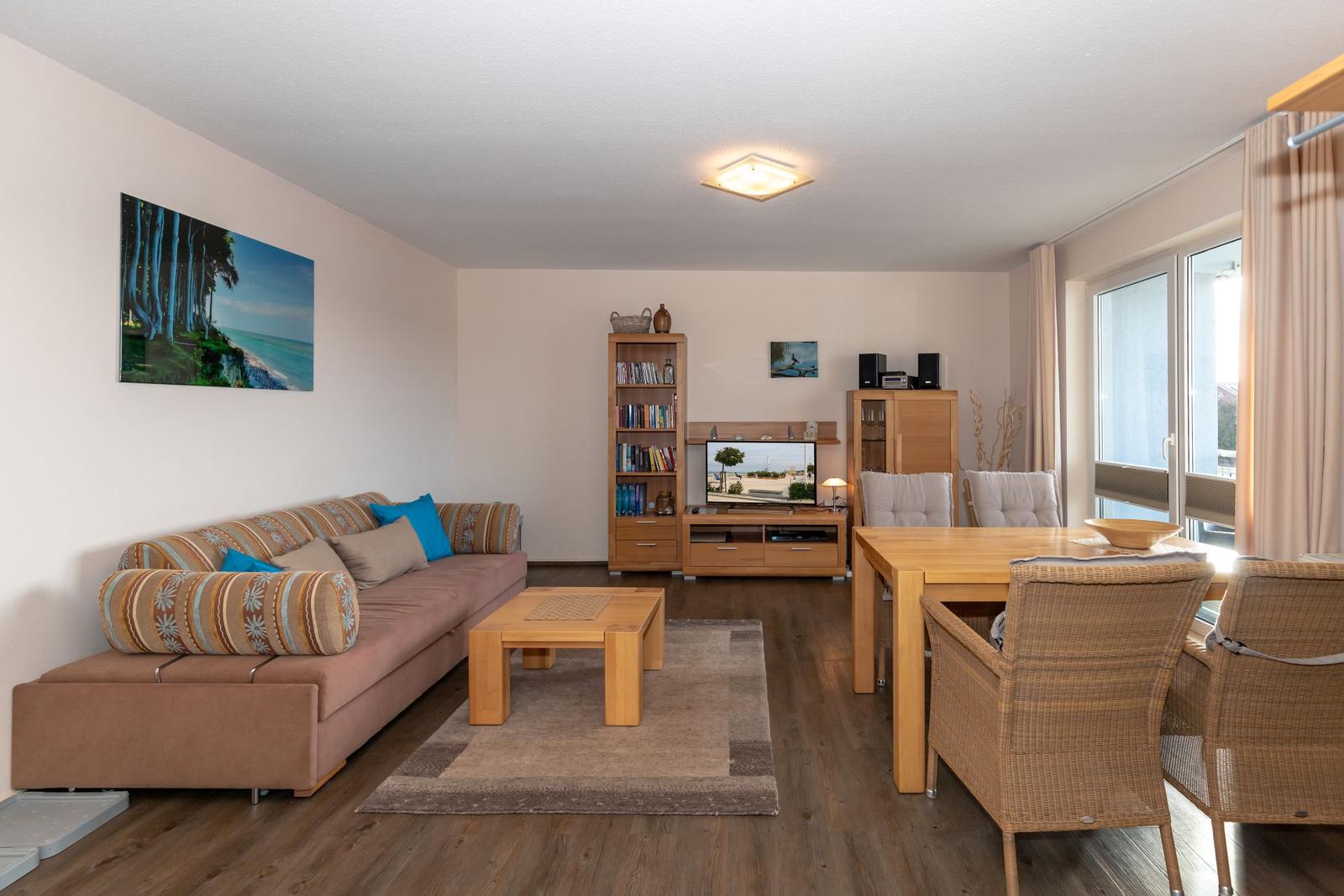 Living and dining area with sofa, dining table, and TV.
