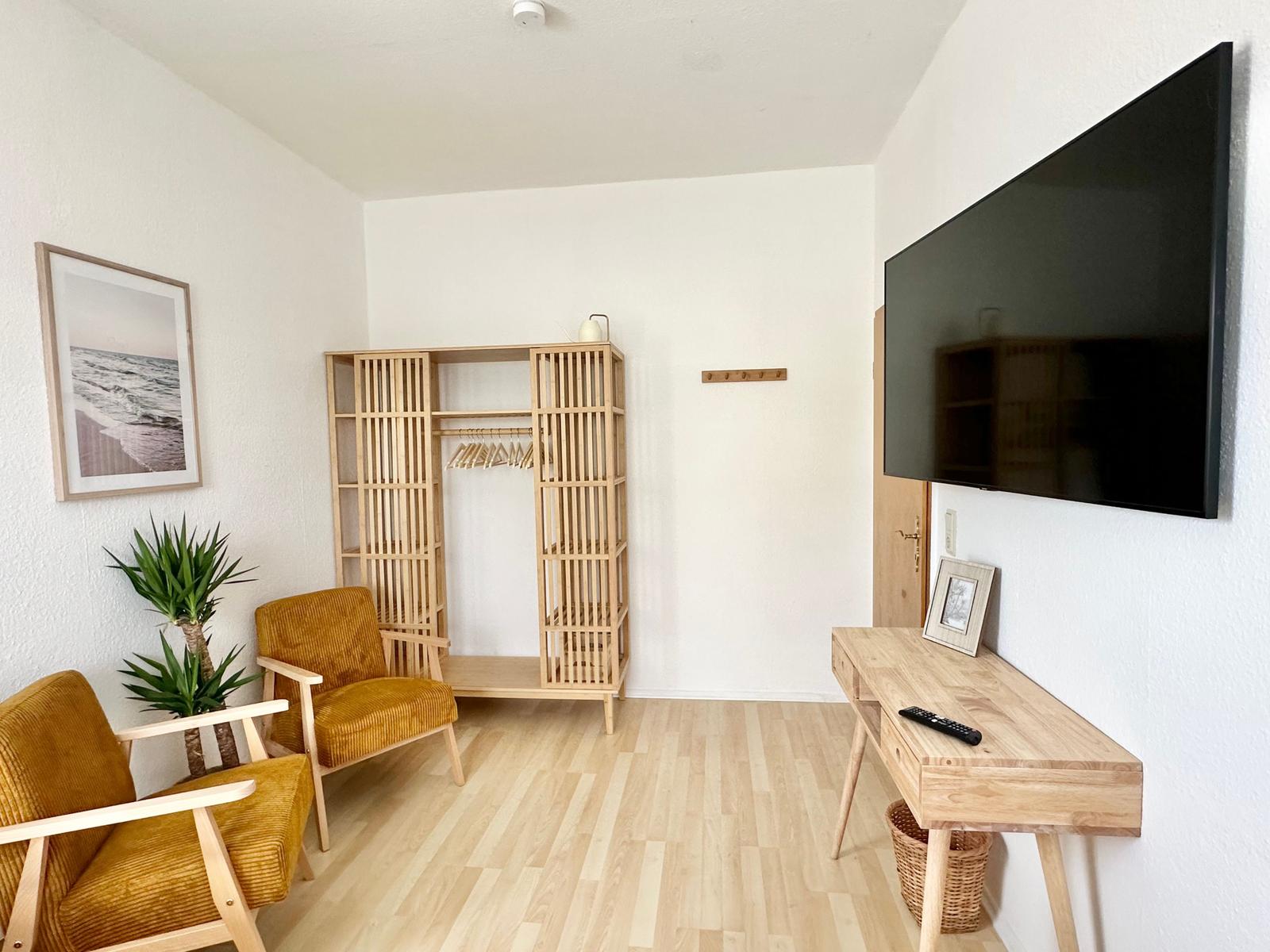 Schlafzimmer 1 mit zwei Einzelbetten (90 x 200 cm), 2 Sessel, Schreibtisch und schwenkbarem 55“ TV