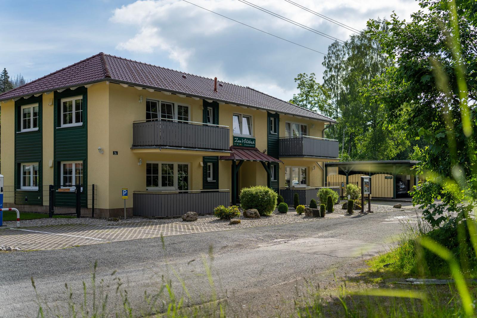 Zwei-Stöckiges Haus mit Balkonen und gepflegtem Gartenbereich.