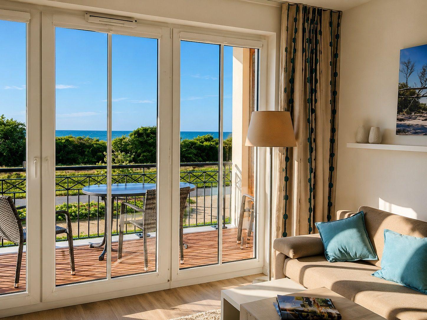 Wohnzimmer mit Blick auf Terrasse und Meer. Sofa mit blauen Kissen.