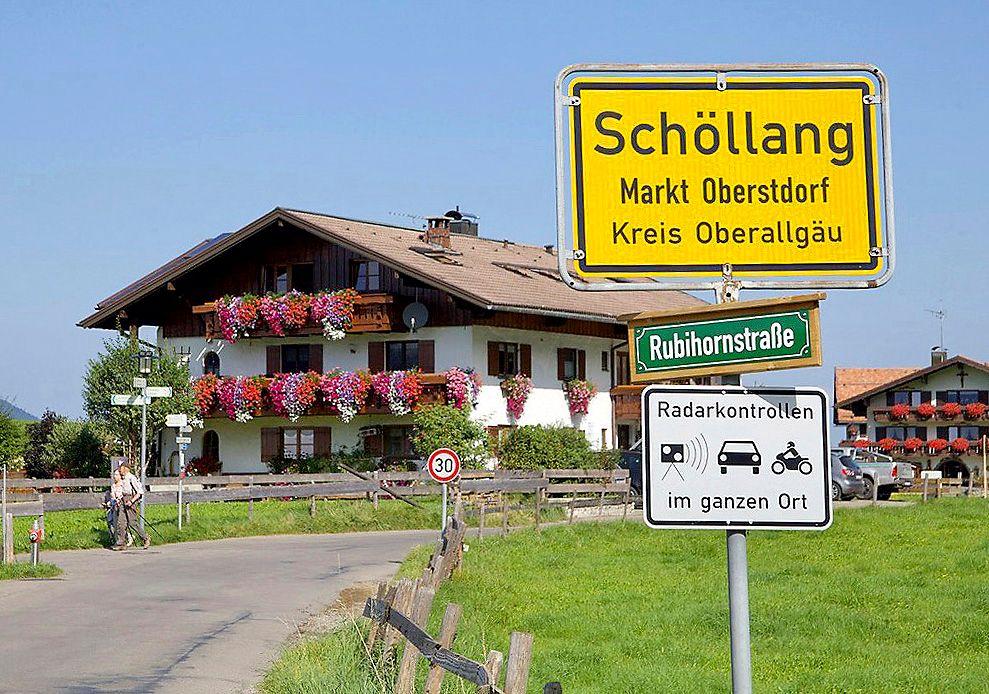 Ortschaftsschild Schöllang mit Straßenschild Rubihornstraße und Radarkontrollen-Schild