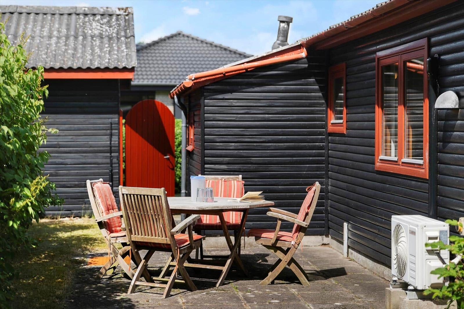 Wohnraum mit Sofa, Stuhl, Tisch und Fenstern.