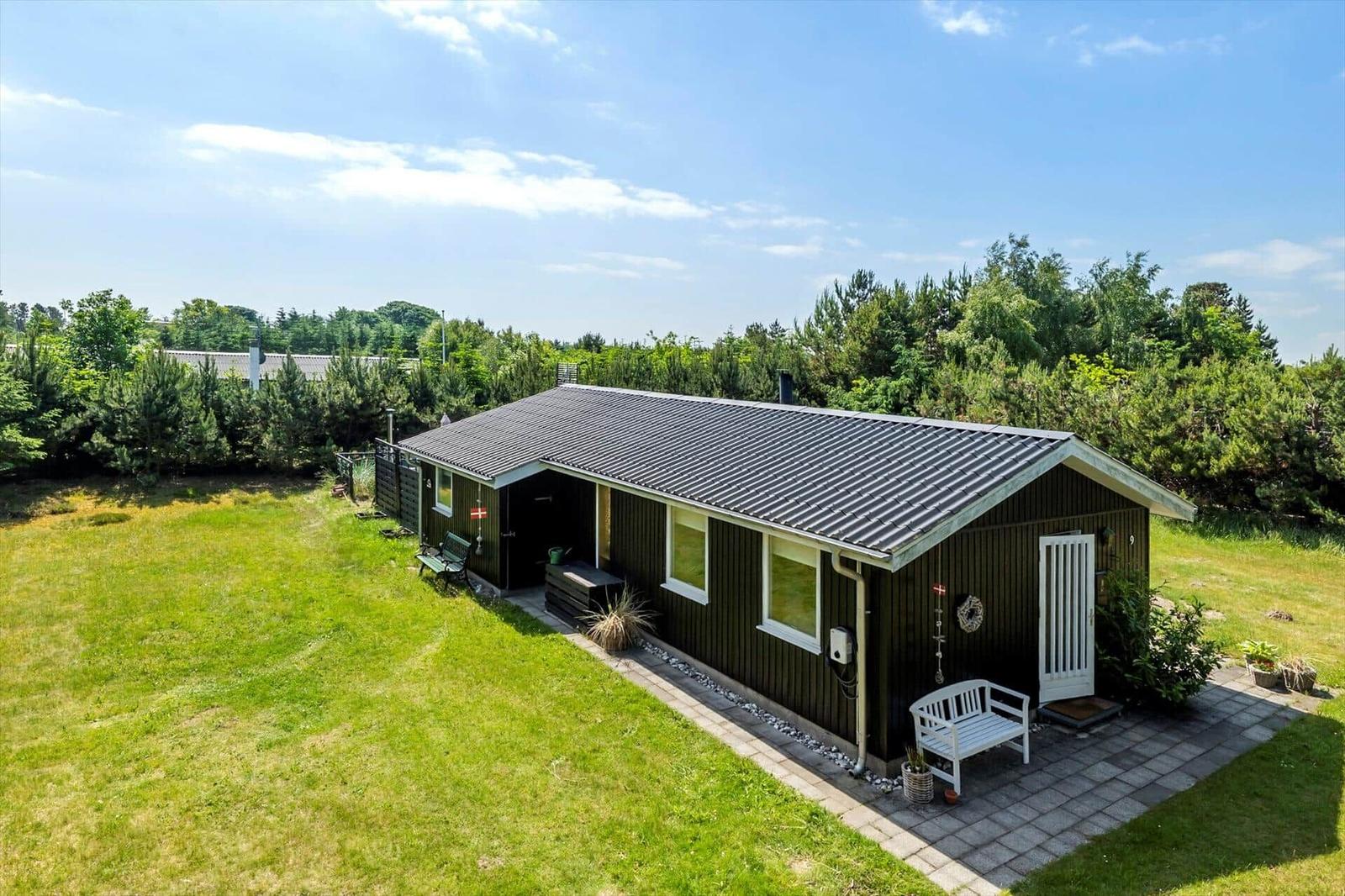 Ein Haus mit Terrasse, Whirlpool und Grillplatz im Grünen.