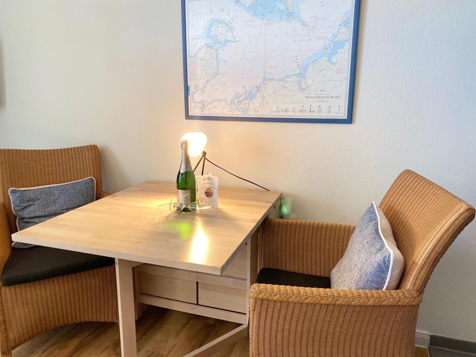 A small table with two chairs and a map on the wall.