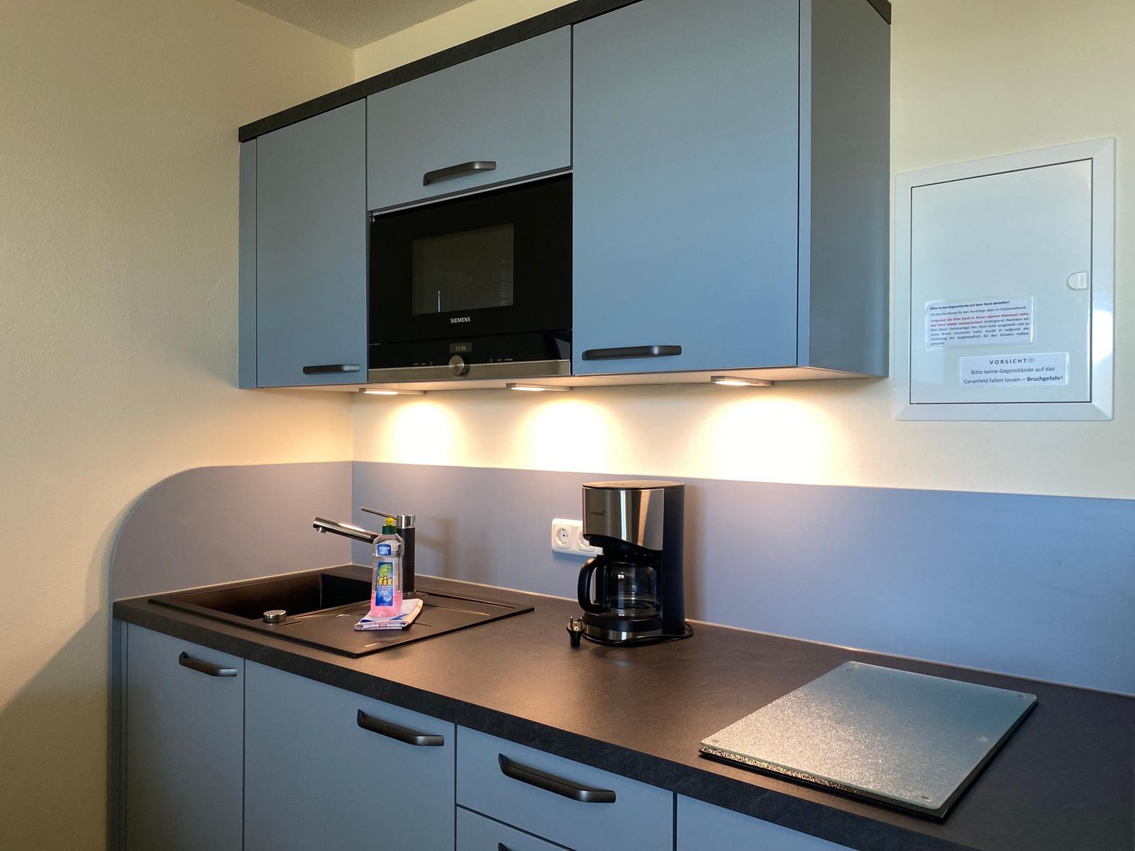 Kitchen with range hood, sink, and coffee maker.