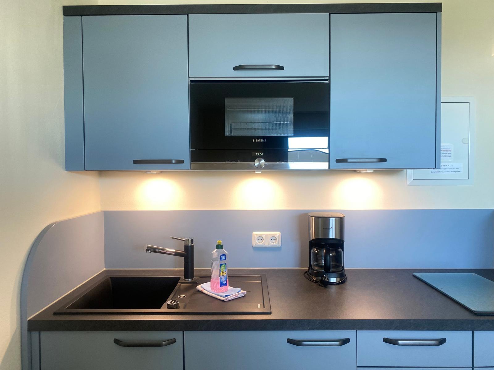 Kitchen with range hood, sink, and coffee maker.