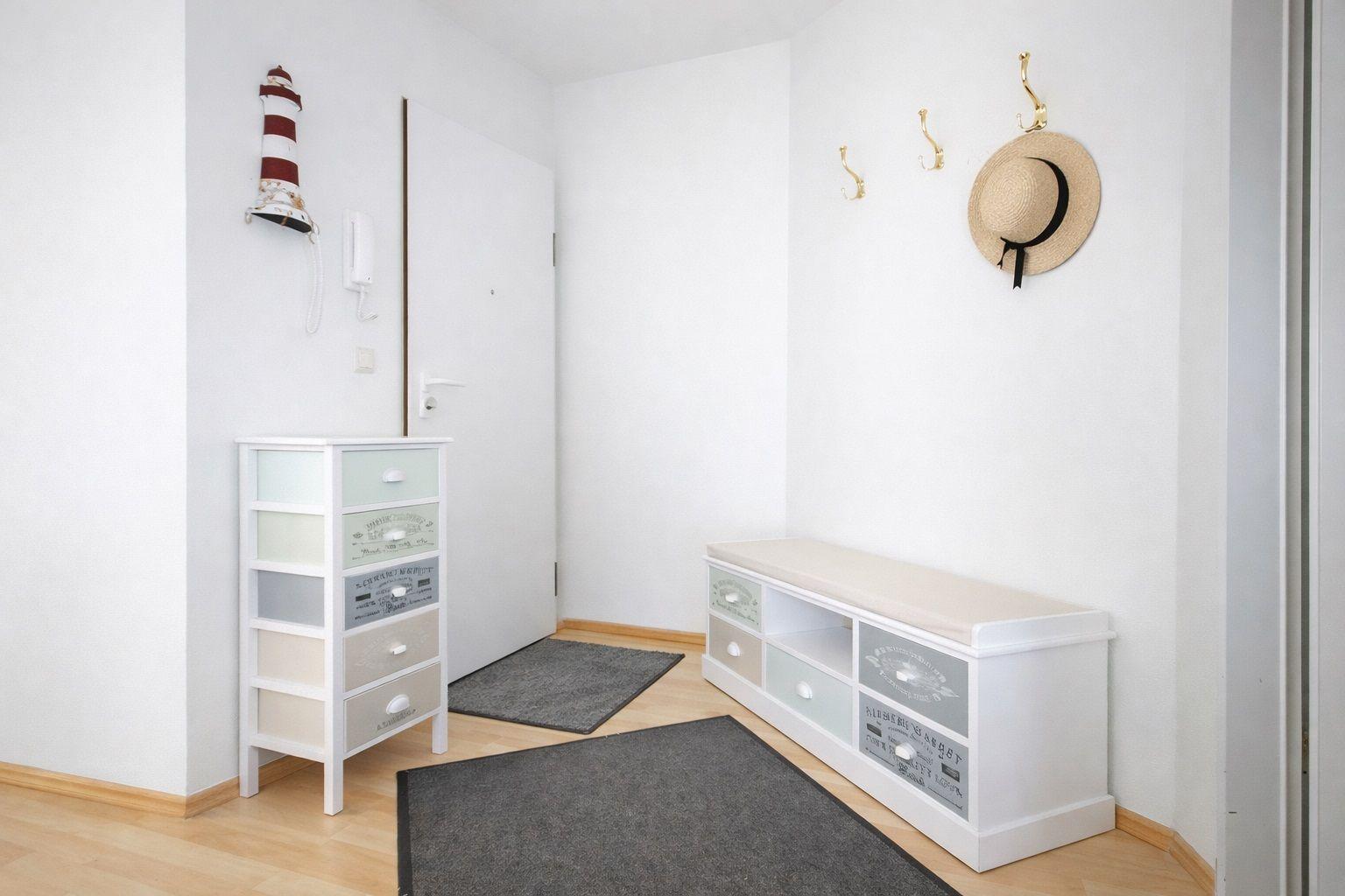 Eingangsbereich mit Schuhschrank, Kleiderschrank und Haken für Mützen und Schuhe.