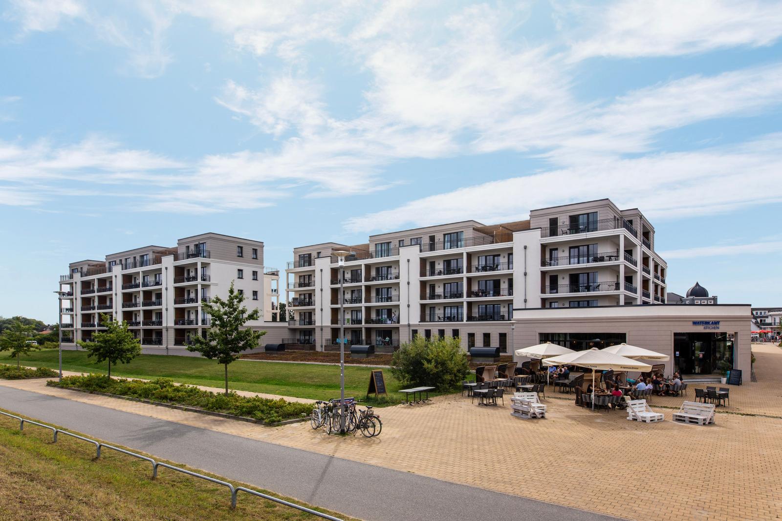 Moderne Ferienwohnung mit Balkon und Außenbereich mit Sitzgelegenheiten.