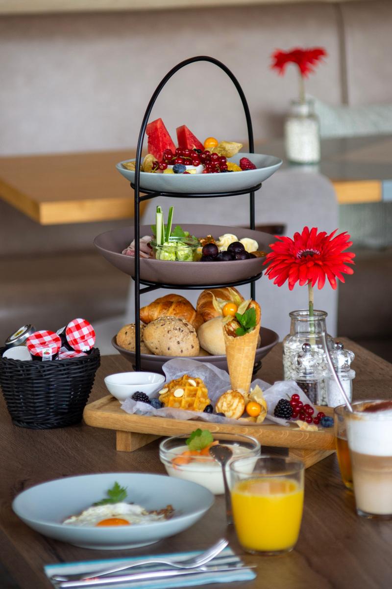 Frühstückstablett mit Obst, Brot und Eiern auf Holztisch