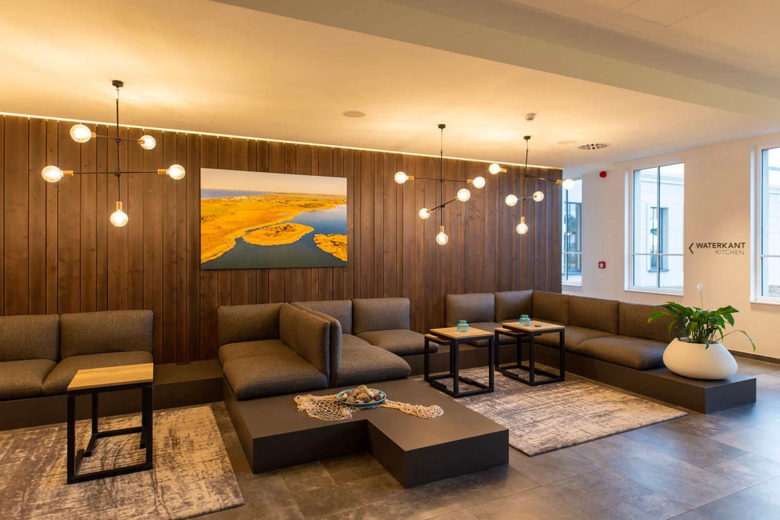 Wohnbereich mit Sofa, Tischen und Wandbild
