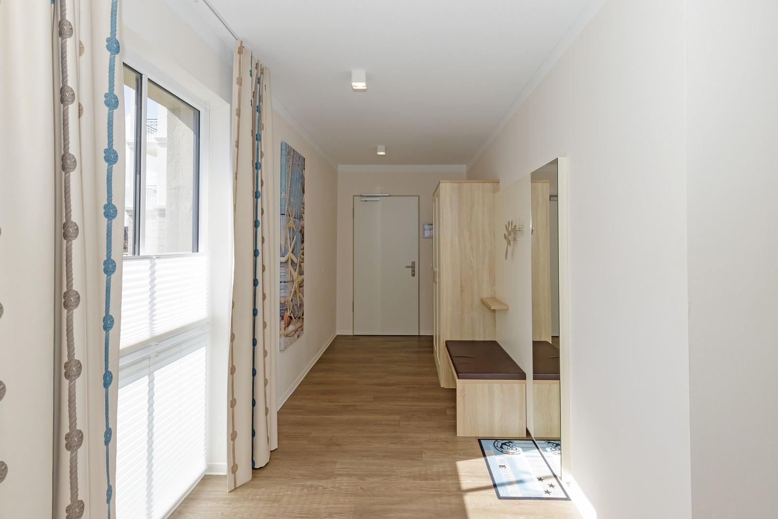 Schlafzimmer mit Kleiderschrank, Sitzbank und Blick in den Schlafbereich.