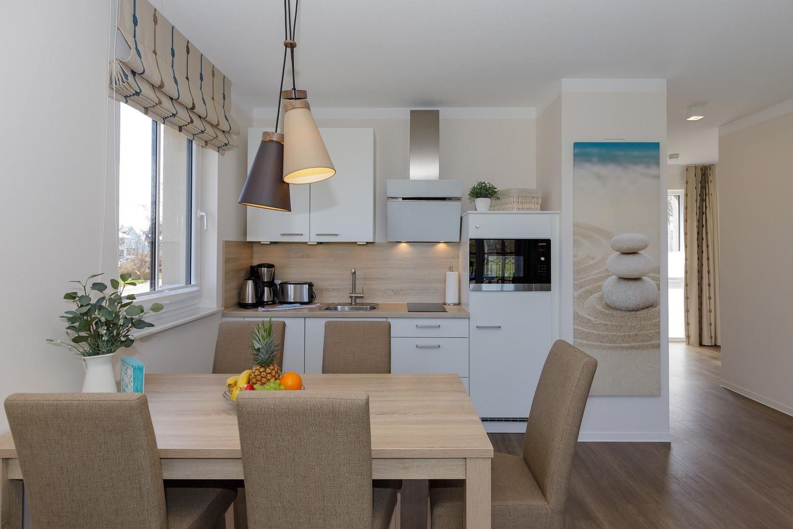 Küche mit Esstisch, Fenster und moderner Einbauküche.