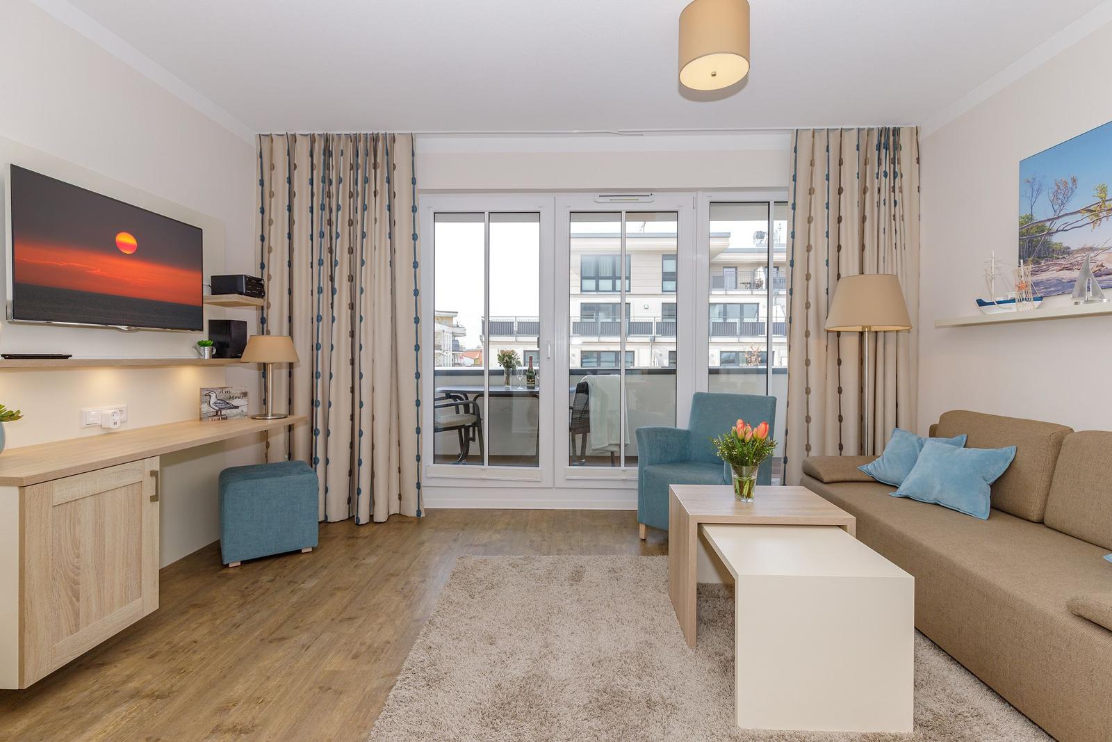 Wohnzimmer mit Sofa, Couchtisch und Balkonansicht.