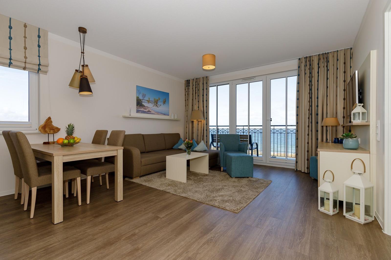 Wohn- und Essbereich mit Blick aufs Meer und Holzboden.
