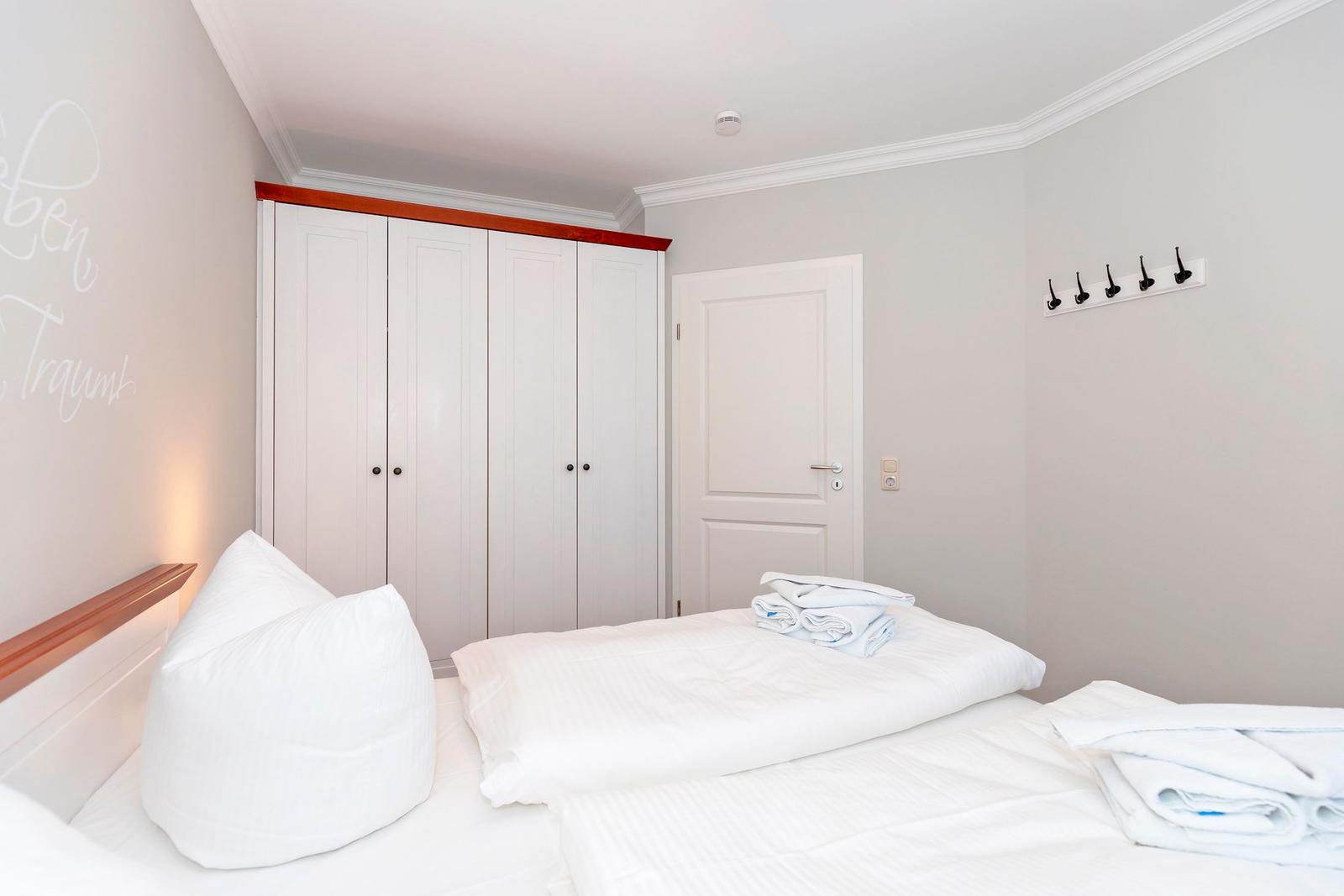 Schlafzimmer mit Bett, Kleiderkammer und Wandschalter