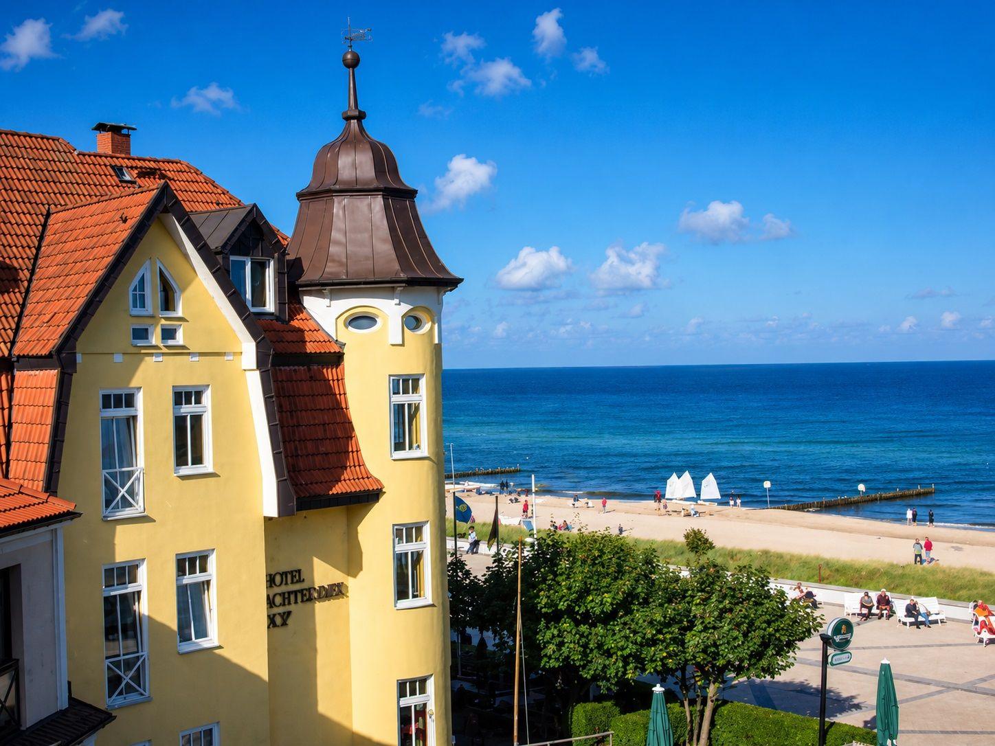 Hotel mit Blick auf Strand und Meer unter blauem Himmel.