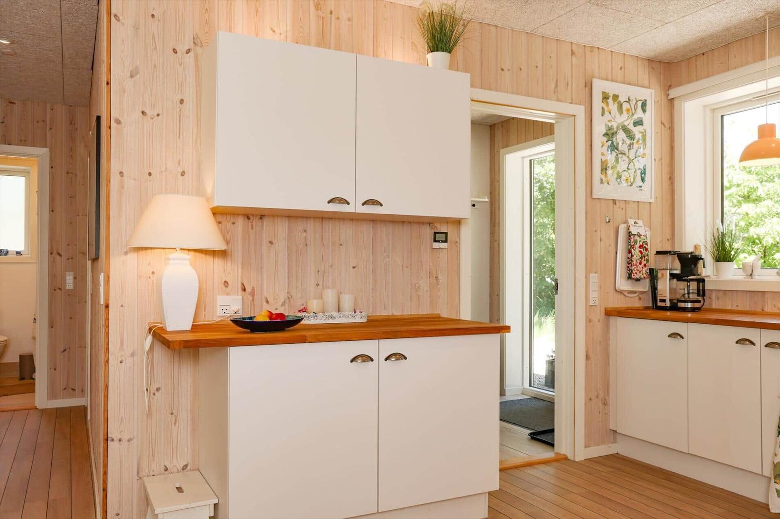 Living room with sofa, table, and windows. Wood wall and ceiling.