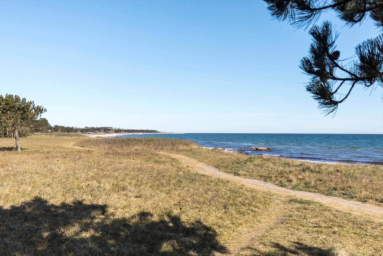 Beach with gravel shore and blue sea under clear sky