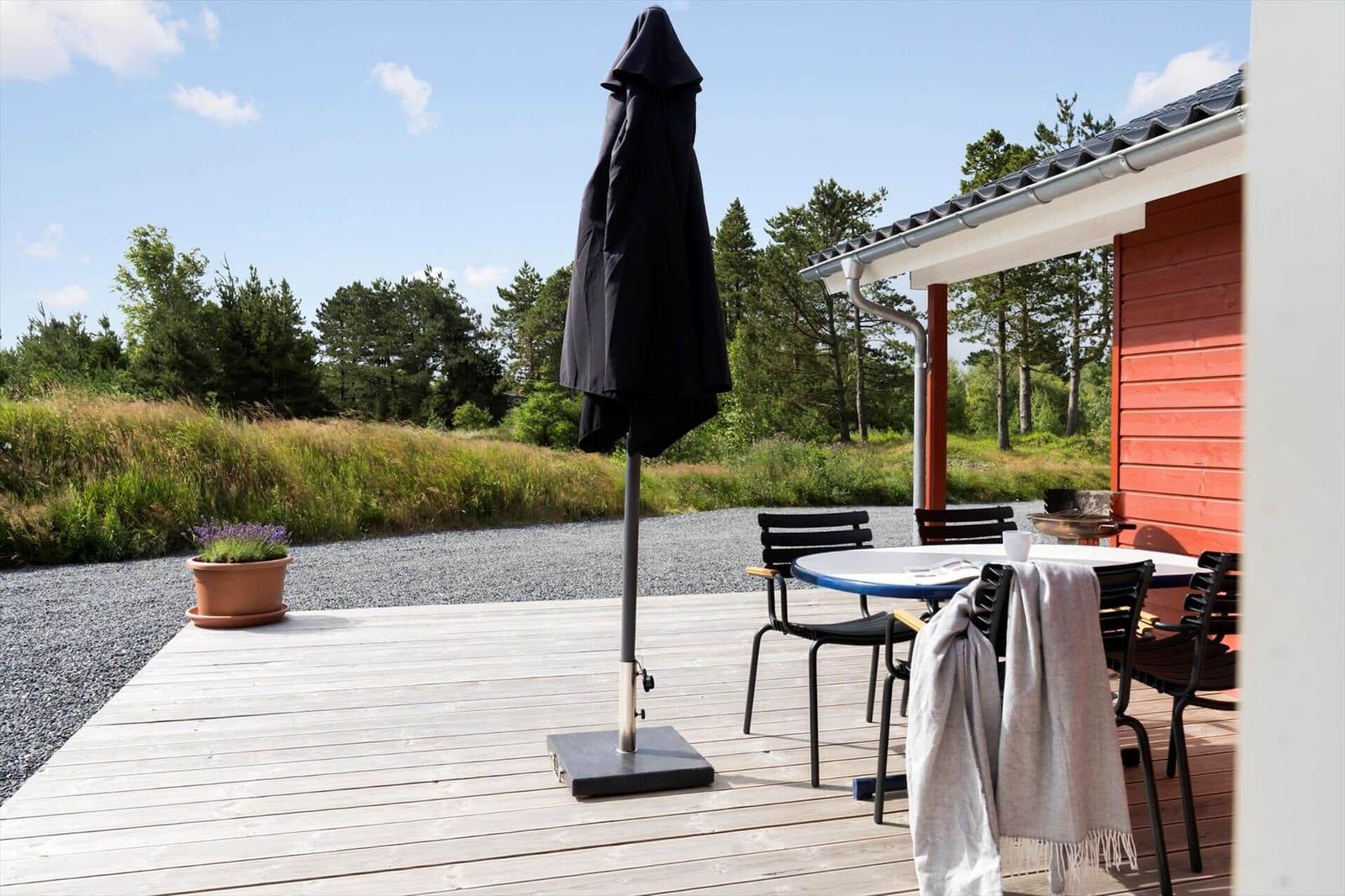 Deck with table and two chairs with checkered cushions.