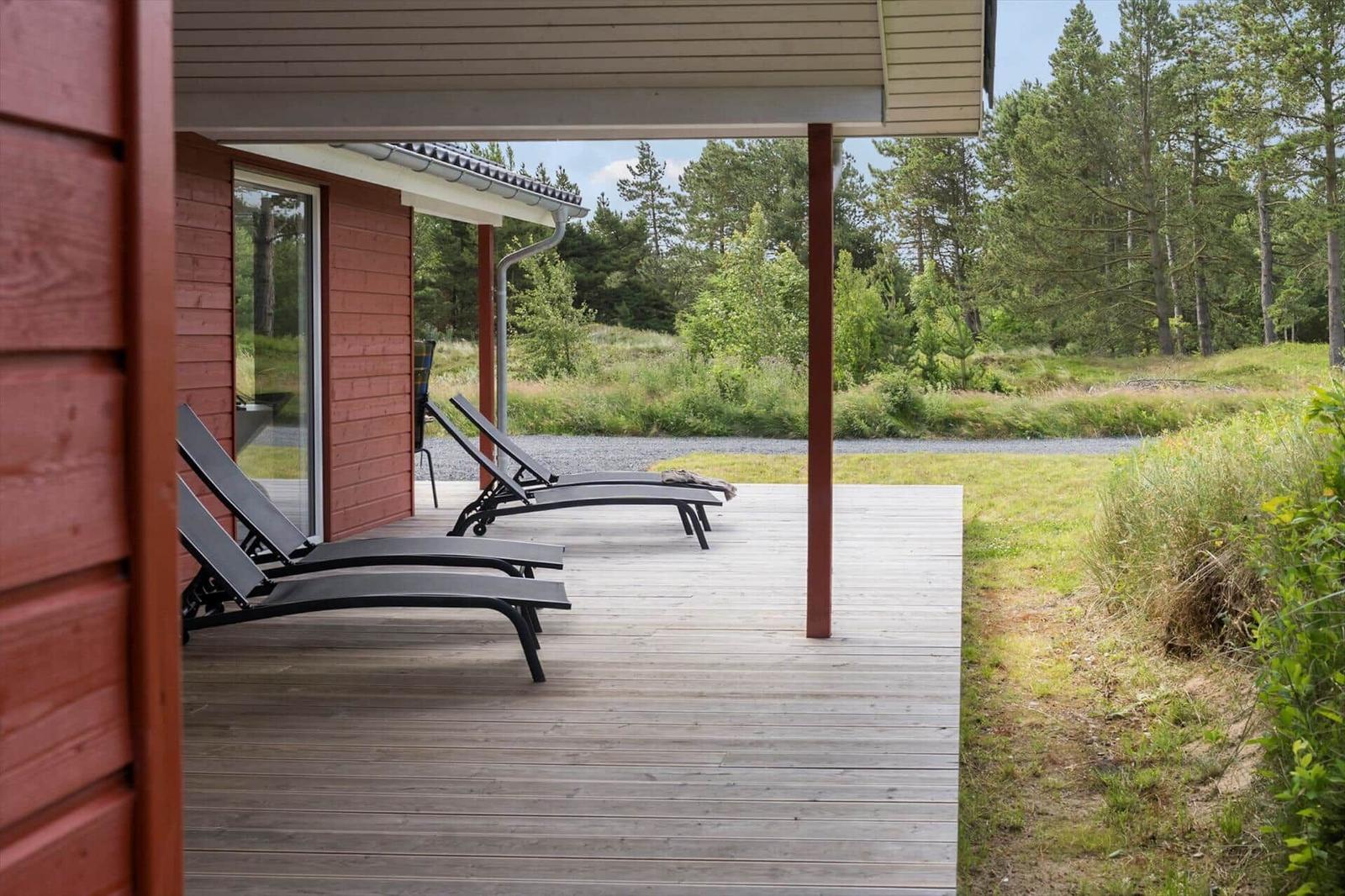 Sauna with wooden walls, bench, and bucket with wooden sticks.